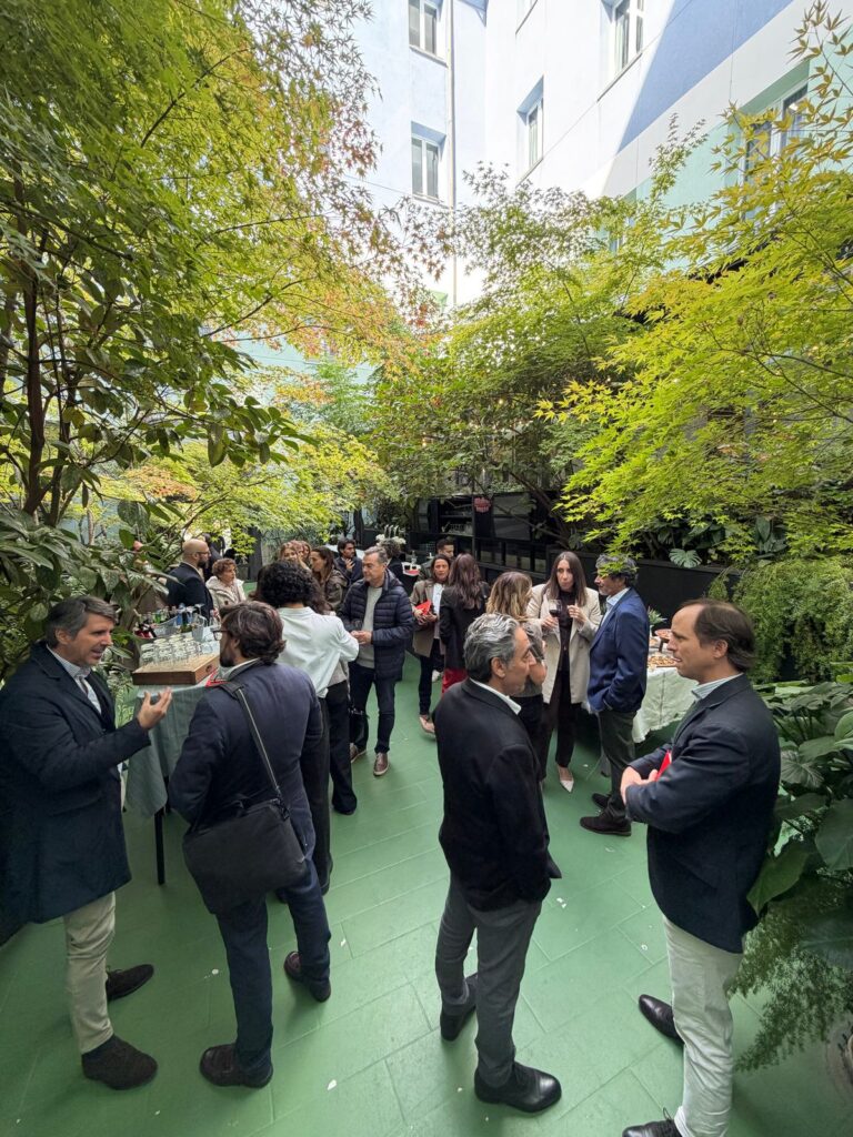 Asistentes conversan en el jardín tras la presentación