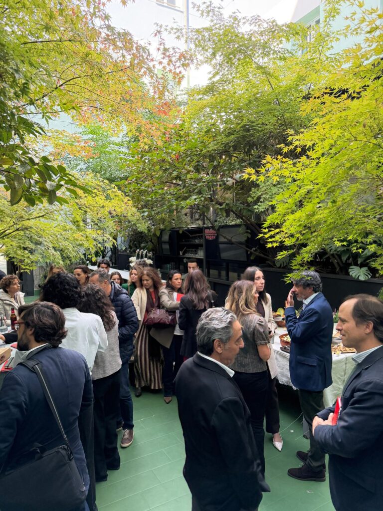 Asistentes conversan durante el cóctel en el jardín